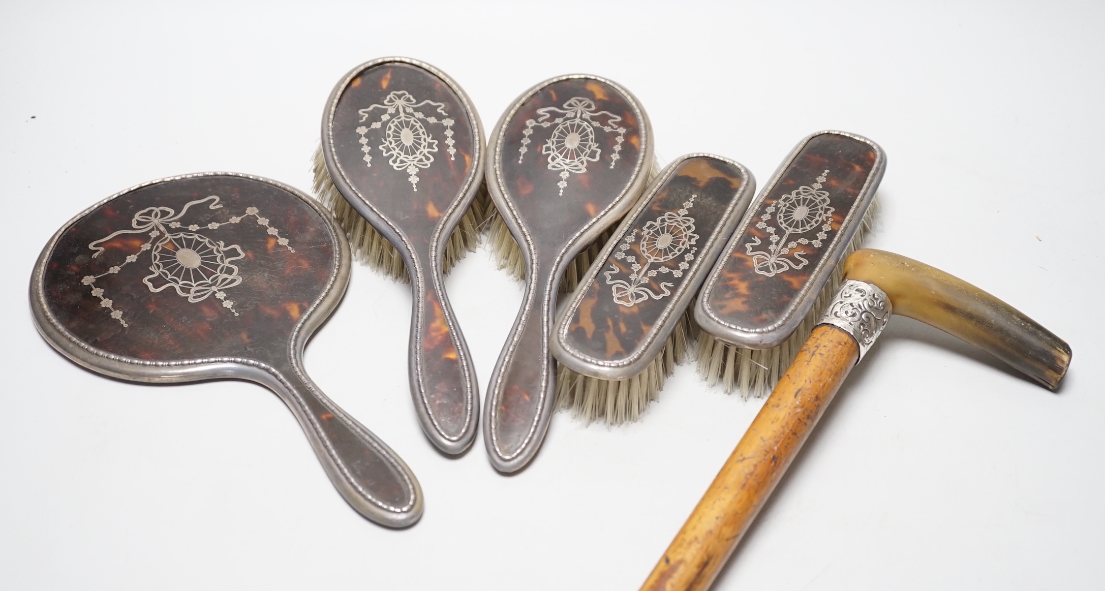 A George V silver and tortoiseshell five piece dressing table set and a silver mounted horn handled malacca walking stick.